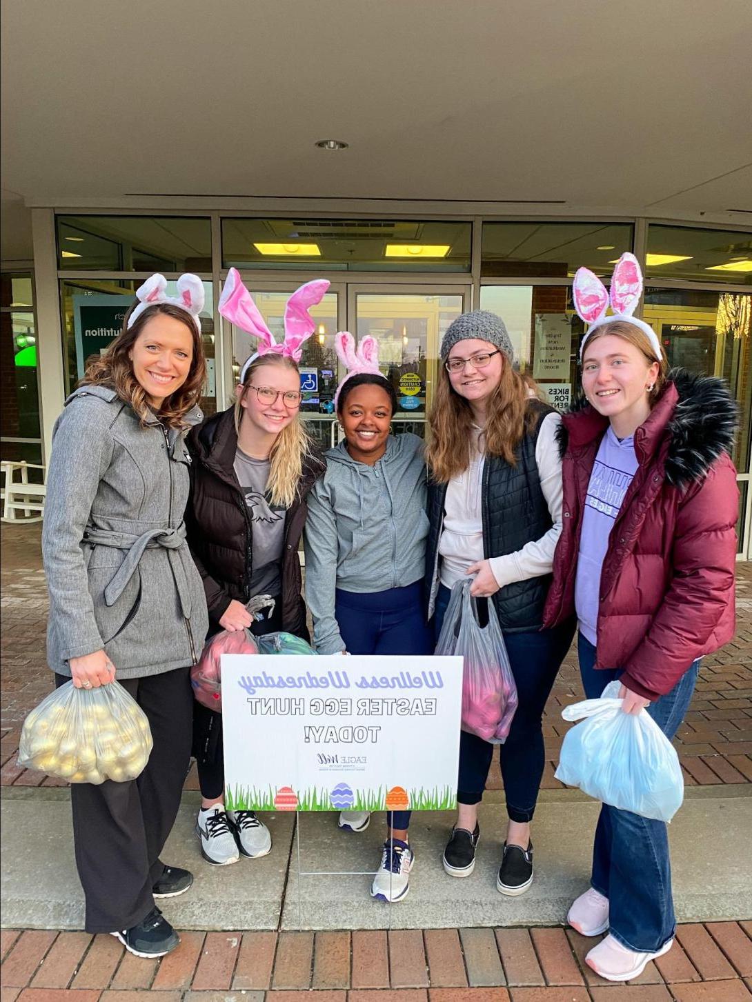 学生们戴着兔子耳朵，拿着一袋袋的彩蛋，参加寻找复活节彩蛋活动.